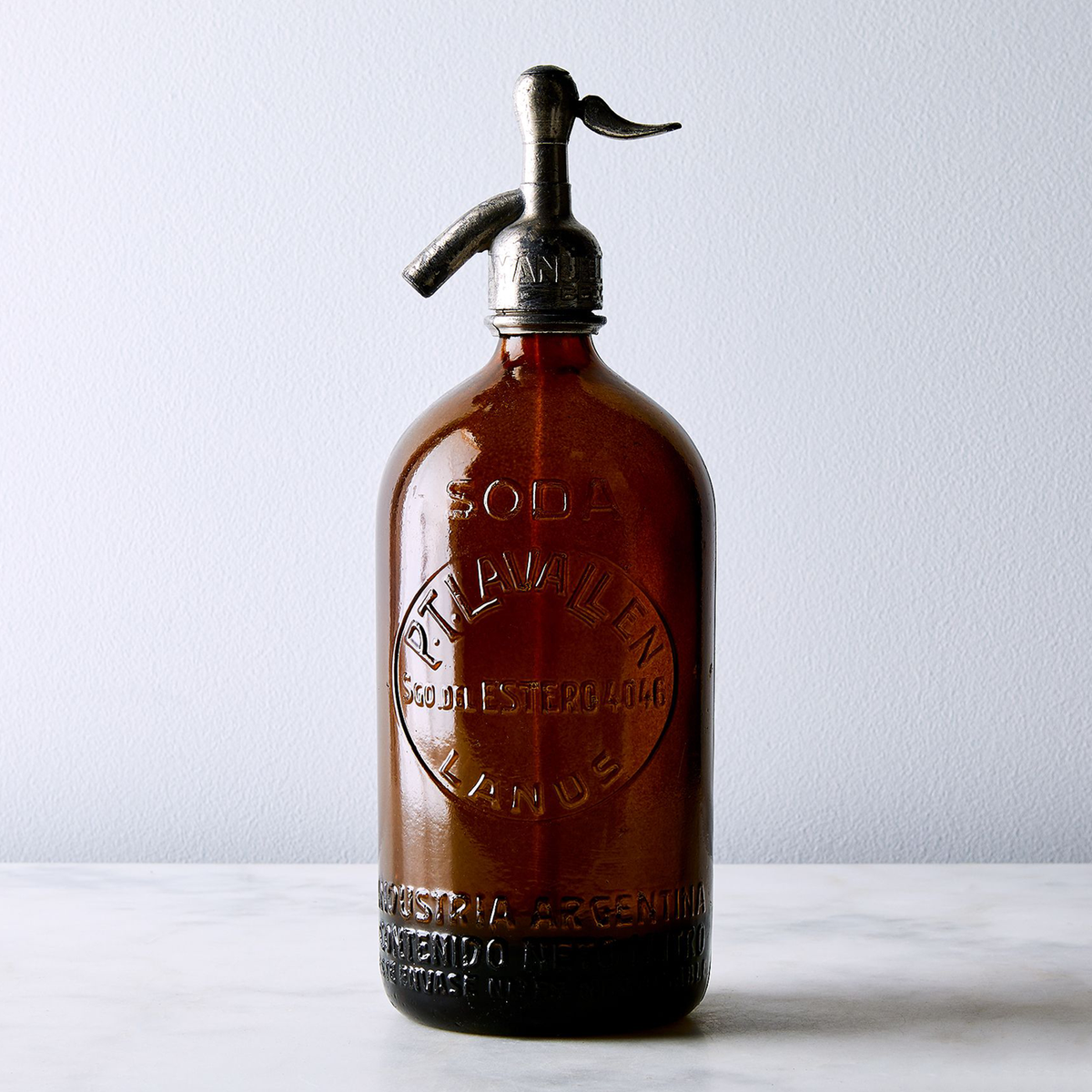 Brown vintage Argentine seltzer bottle with embossed name and address in deep tobacco glass